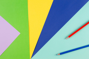Obraz premium Colored paper with red and blue pencils
