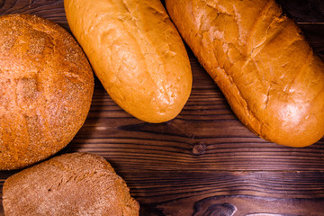Different loafs of bread on wooden table. Top view