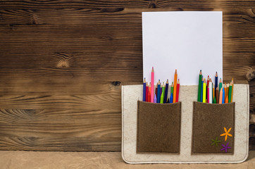 Obraz premium Color pencils and blank page paper with copy space in a bag pocket. Drawing set. Artist bag. Certificate of the artist mock up.