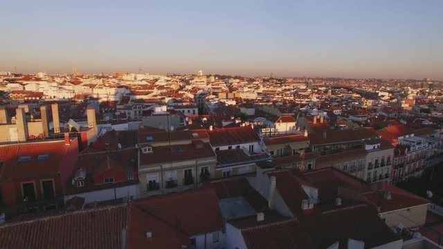 Drone flies over big european ancient city, with historic part of town with small houses with red tile roofs, inspiring image of madrid at sunset time