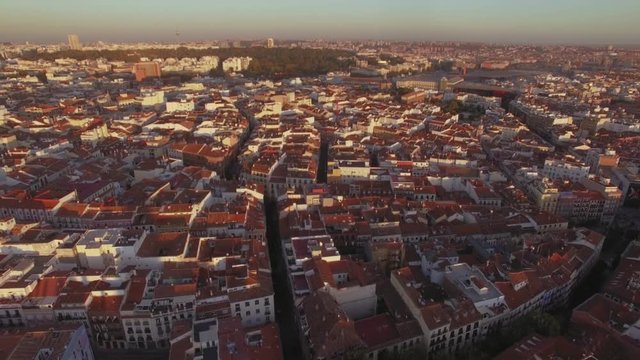 Aerial footage from drone flying over and shows grid and city planning of old ancient european town, city with red tiles roofs, sunset light over big village, destination for tourists, madrid, spain