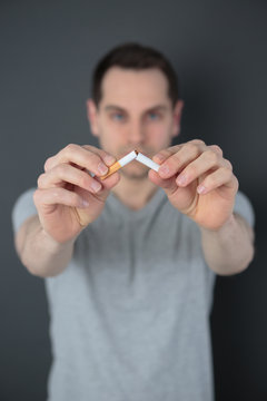 adult man breaking cigarette