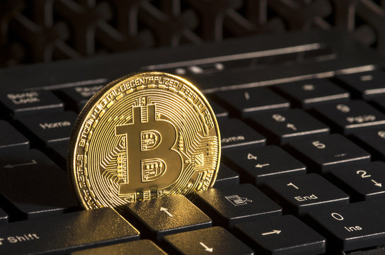 Golden bitcoin on keyboard 
