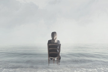 lonely woman sitting on shore at the ocean looks at infinity - Powered by Adobe