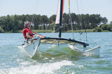 man sailing with sails out on a sunny day