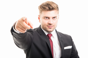Portrait of handsome corporate business man pointing camera