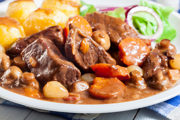 Beef Bourguignon stew served with baked potatoes