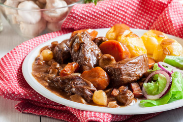 Beef Bourguignon stew served with baked potatoes