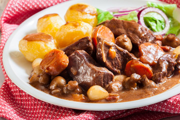 Beef Bourguignon stew served with baked potatoes