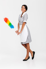 Full length photo of attractive housekeeper posing with colorful duster and looking at camera