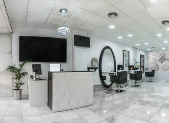 Reception in a beauty salon with desk,plant and banners. Hair salon interior.