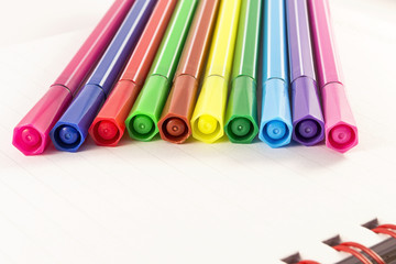 Color markers on white notebook