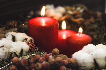 Red christmas candles with berries on a dark background