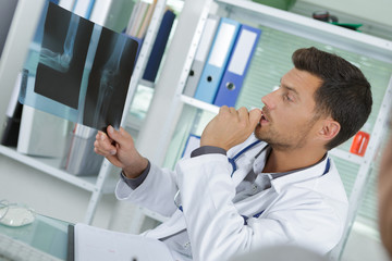 Naklejka na ściany i meble male doctor looking at a x-ray
