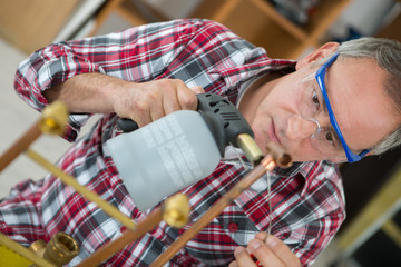 man using a blowtorch with cooper pippes