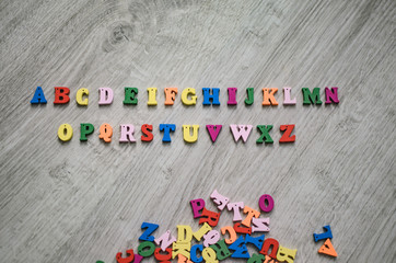 Multicolored letters of the alphabet on a wooden background
