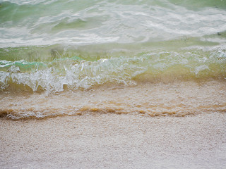 Falling sea wave on a sandy shore.