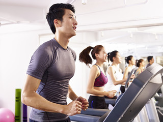 Fototapeta premium asian young people working out on treadmill