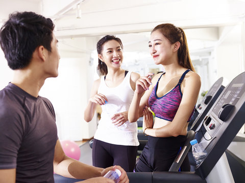 asian young people chatting in gym