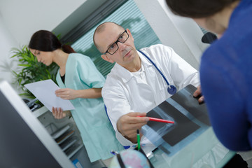 doctor showing xray to his patient in medical office