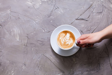 Cup of cappuccino with figure cream