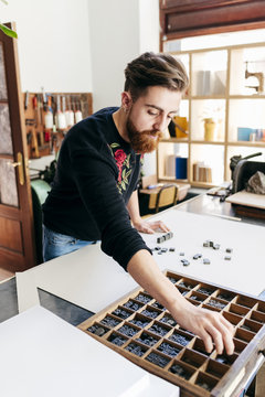 Worker arranging printing letters