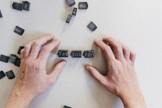 Crop man arranging printing letters
