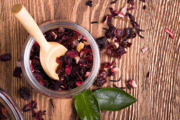 Herbal aroma fruit tea dry leaves on spoon on wooden background