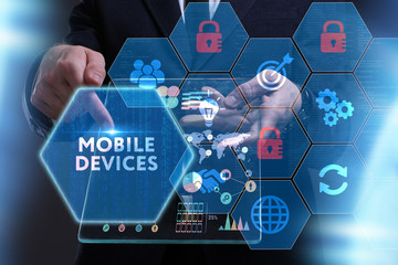 Business, Technology, Internet and network concept. Young businessman working on a virtual screen of the future and sees the inscription: Mobile devices