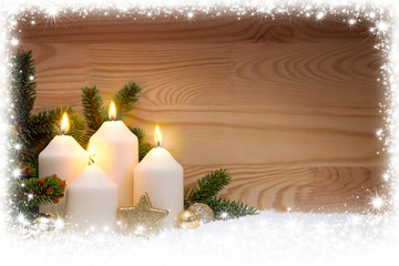 Four burning Advent candles and snow frame.