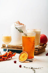 Set of various winter cocktails: mulled wine, eggnog, limoncello, old-fashioned, coconut margarita. White linen background. Vertical composition.