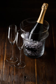 Picture of two glasses, bucket of ice and bottle of wine