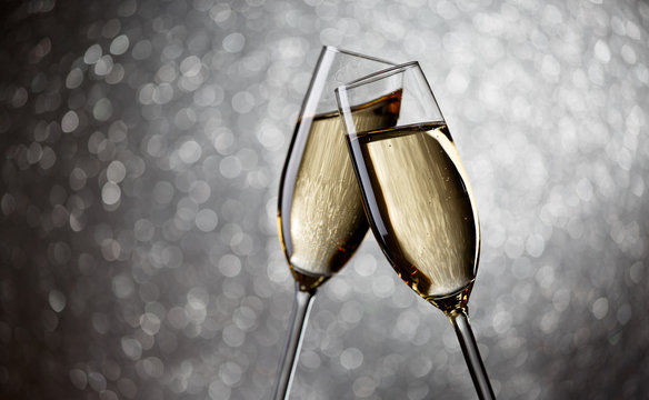 Photo of two glasses with champagne on gray background,