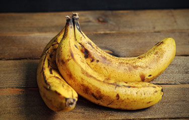 three bananas on wooden background