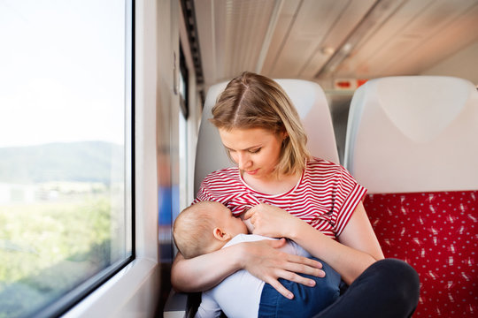 Young mother travelling with baby by train.