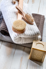 Fototapeta na wymiar solid soap, body brush, hairbrush and towels for green bath