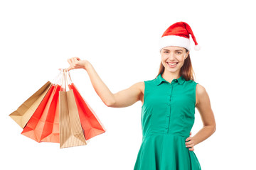 Studio portrait of young woman in Santa hat posing with shopping bags on white background