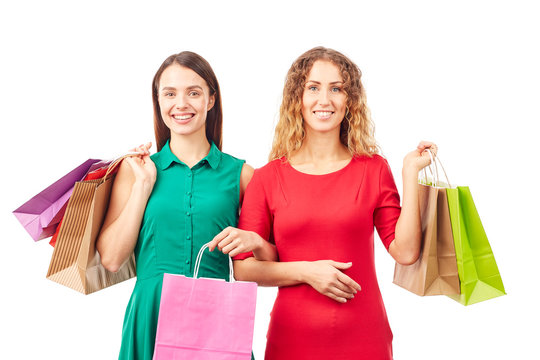 Portrait of two female friends holding multi-colored shopping bags