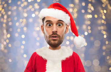 man in santa claus costume over christmas lights