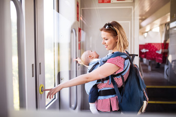 Young mother travelling with baby by train.