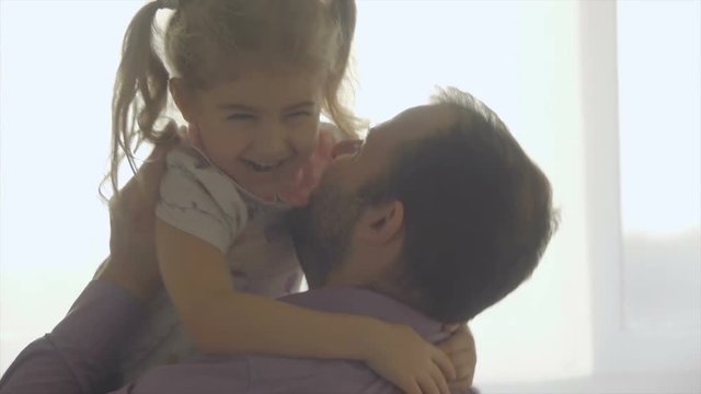 Little Daughter Rushes Into father Arms At Home. Slow motion. Big Hug. Family values. Kiss.
