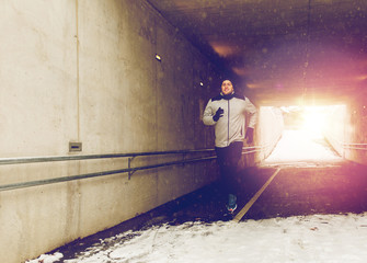 happy man running along subway tunnel in winter