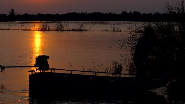 Silhouette of Boat carrying flood victims, has been affected by the floods, at sunset.