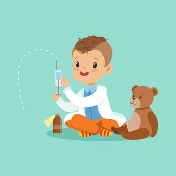 Adorable baby boy dressed as a doctor playing with teddy bear toy. Kid preparing syringe for his sick patient