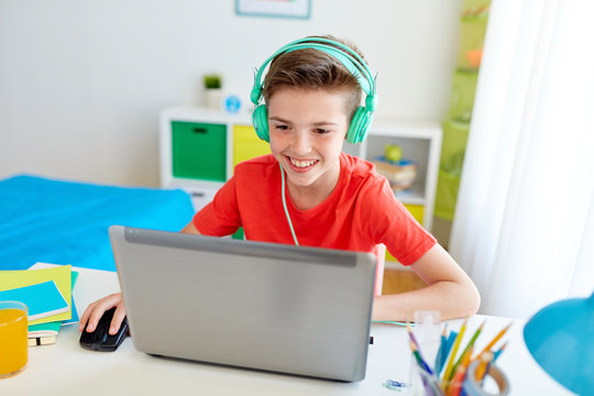 Boy In Headphones Playing Video Game On Laptop