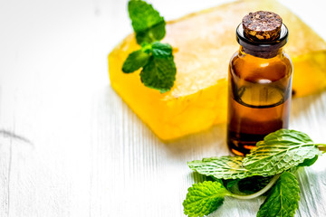 organic cosmetics with herbal extracts of mint on wooden backgro