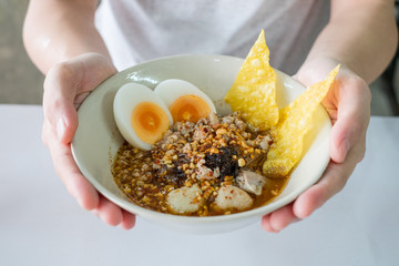 Serving Spicy noodle with eggs and crispy wonton.