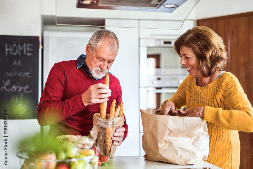 Poster Senior couple preparing food in the kitchen.