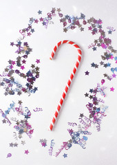 Christmas or New year festive background. Greeting card composition with striped candy and glitters. Holidays concept.