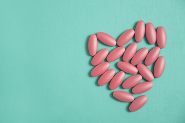 The heart made of tablets and pills on blue background
